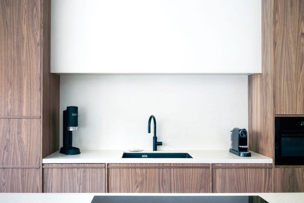Moderne keuken met kasten in Notelaar hout en witte muren